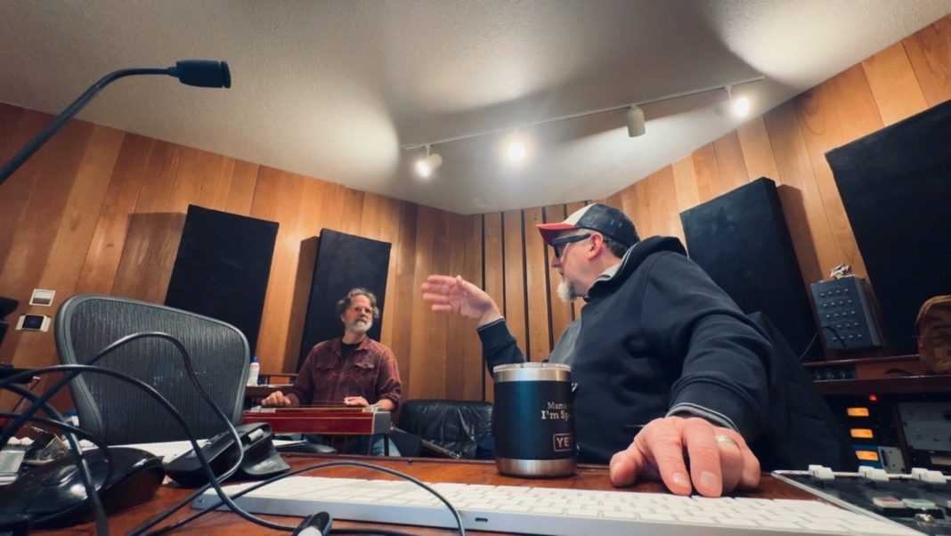 Matt Boudreau at the console during a session, with pedal steel player Dave Zirbel in the room behind him.